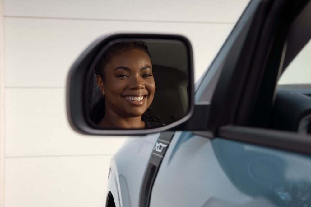 Gabrielle Union smiling in the side mirror of a 2022 Ford Maverick XLT