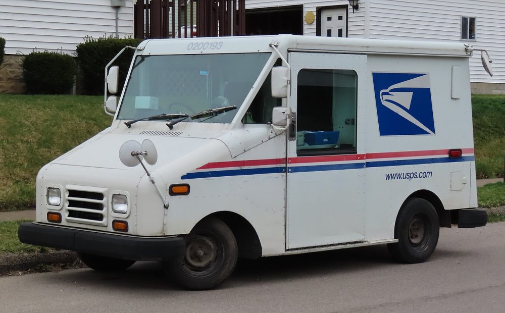 A Grumman LLV mail delivery vehicle sitting at the curbside