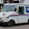 A Grumman LLV mail delivery vehicle sitting at the curbside
