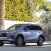 2022 INFINITI QX60 in front of a staircase and ivy-lined wall