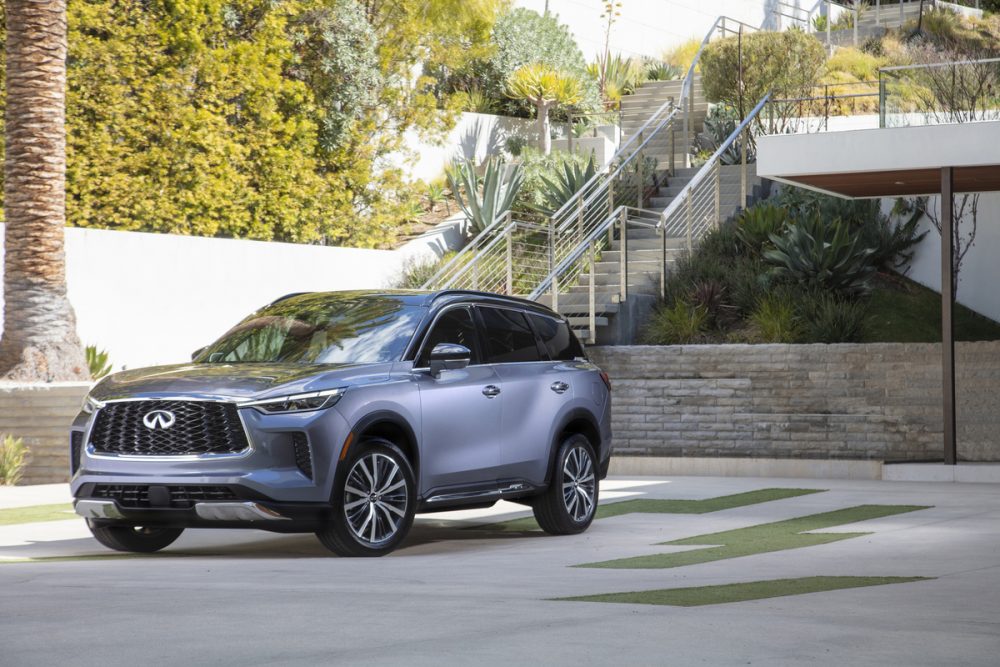 2022 INFINITI QX60 in front of a staircase and ivy-lined wall