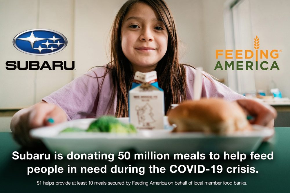 Subaru Feeding America young girl with food tray smiling at camera