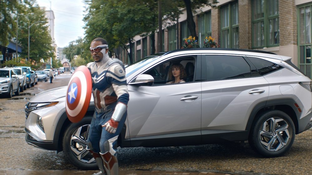 Still photo from ad: Captain America holds shield while standing next to 2022 Hyundai Tucson