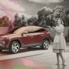 Ad still: black-and-white Wanda Maximoff stands next to red 2022 Hyundai Tucson