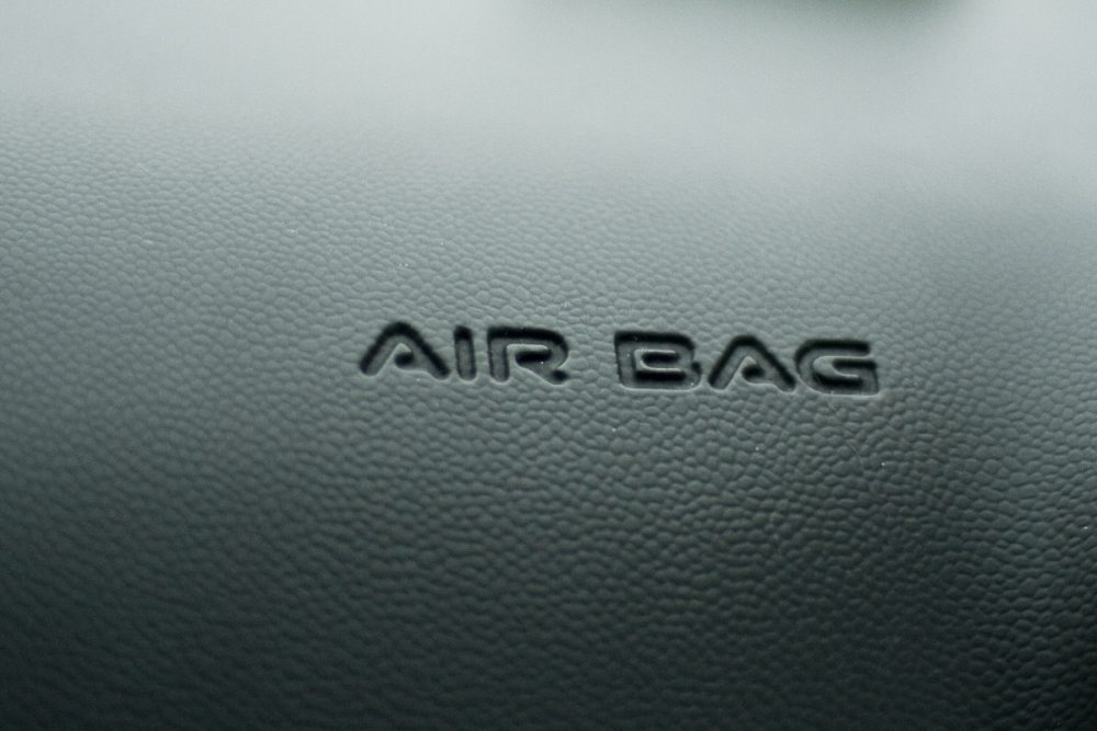 close up photo of black car dashboard with air bag written across