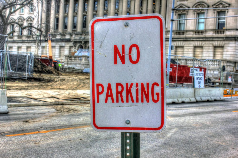 No Parking Sign on a street with construction in the background.