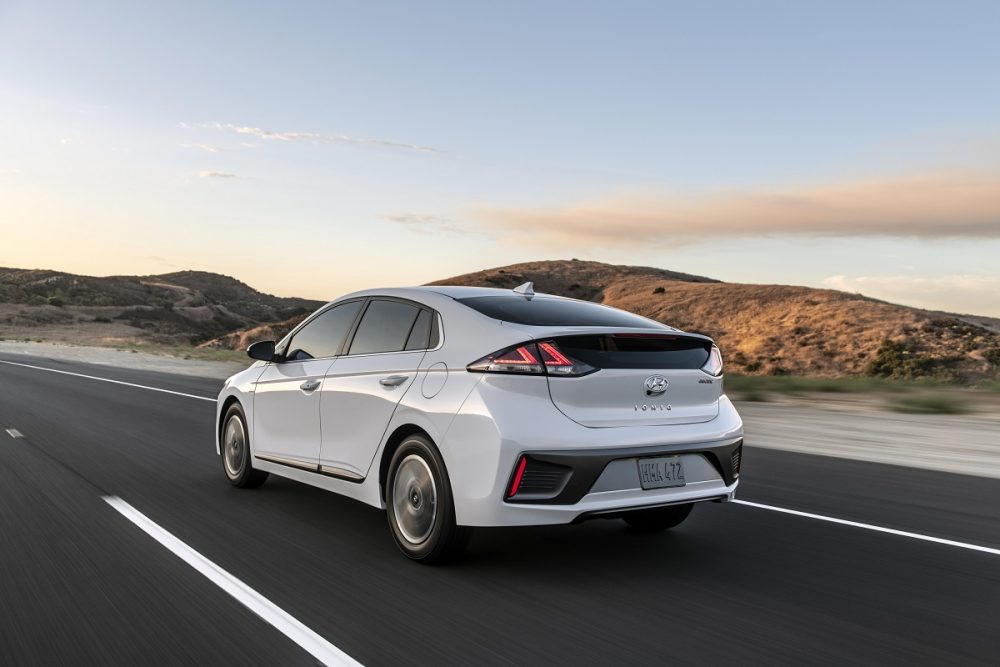 Rear side view of 2021 Hyundai Ioniq Electric driving down road