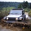 The 2021 Jeep Wrangler Rubicon with the Sunrider Flip Top for Hardtop driving through mud