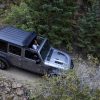 The 2021 Jeep Wrangler Rubicon with the Sunrider Flip Top for Hardtop driving through mud