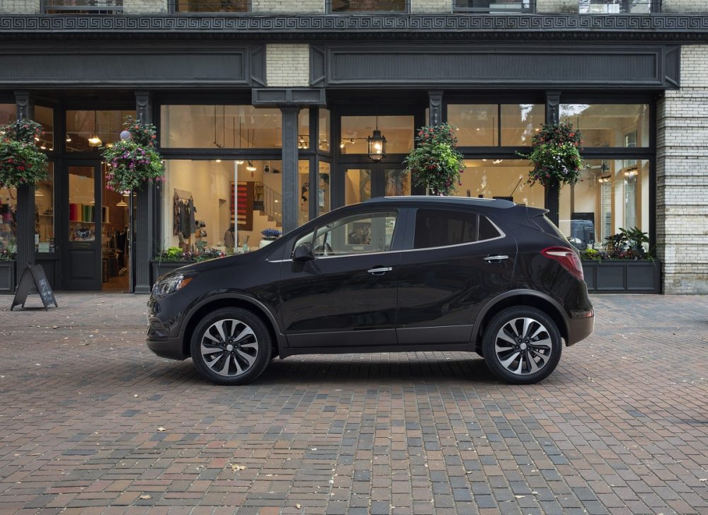 The side profile of a 2022 Buick Encore parked in front a building