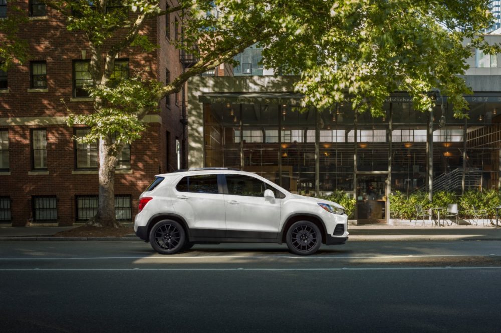 Profile view of white 2022 Chevrolet Trax on tree-lined street