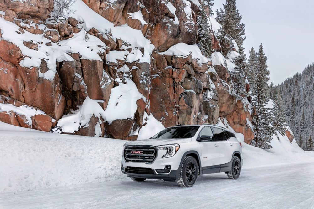 2022 GMC Terrain AT4 parked by a snow-covered rocky outcropping