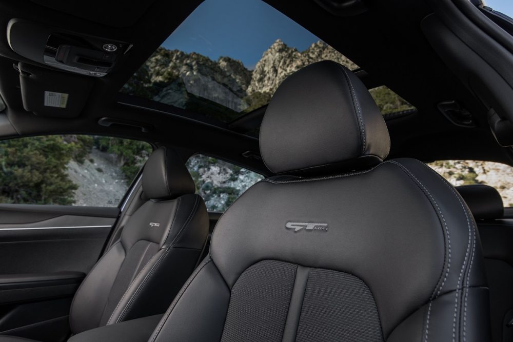 Close up of 2022 Kia K5 GT-Line front seats with panoramic sunroof behind