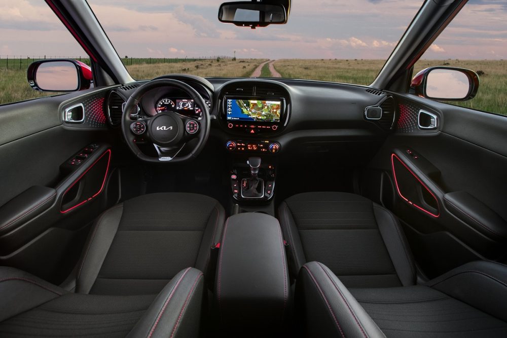 2022 Kia Soul interior in black with red accents and the 10.25-inch touch screen display lit up