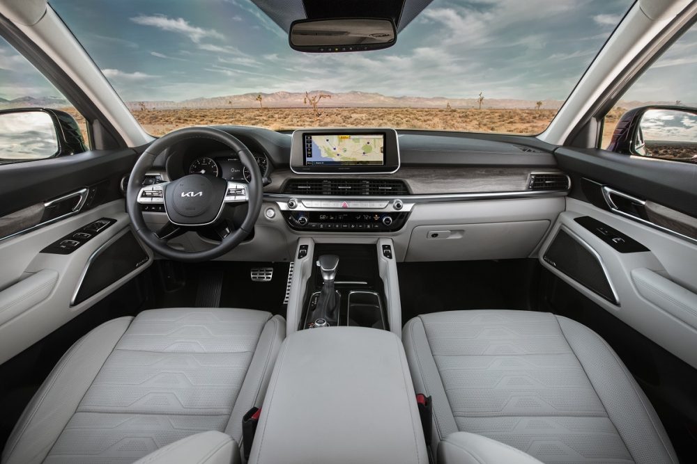 Front seat view of the 2022 Kia Telluride interior in white leather and wood grain trim