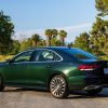 Side rear photo of a Racing Green Metallic 2022 Volkswagen Passat Limited Edition model parked in front of a grassy area