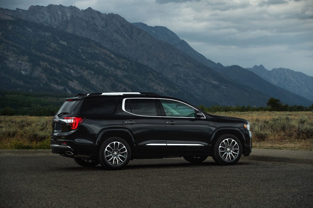 Side view of parked GMC Acadia Denali with mountains in background