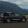 Side view of parked GMC Acadia Denali with mountains in background