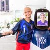 Cancer patient and soccer player Luna Perrone poses with the CHAMP robot with Alex Morgan's face displayed on its screen