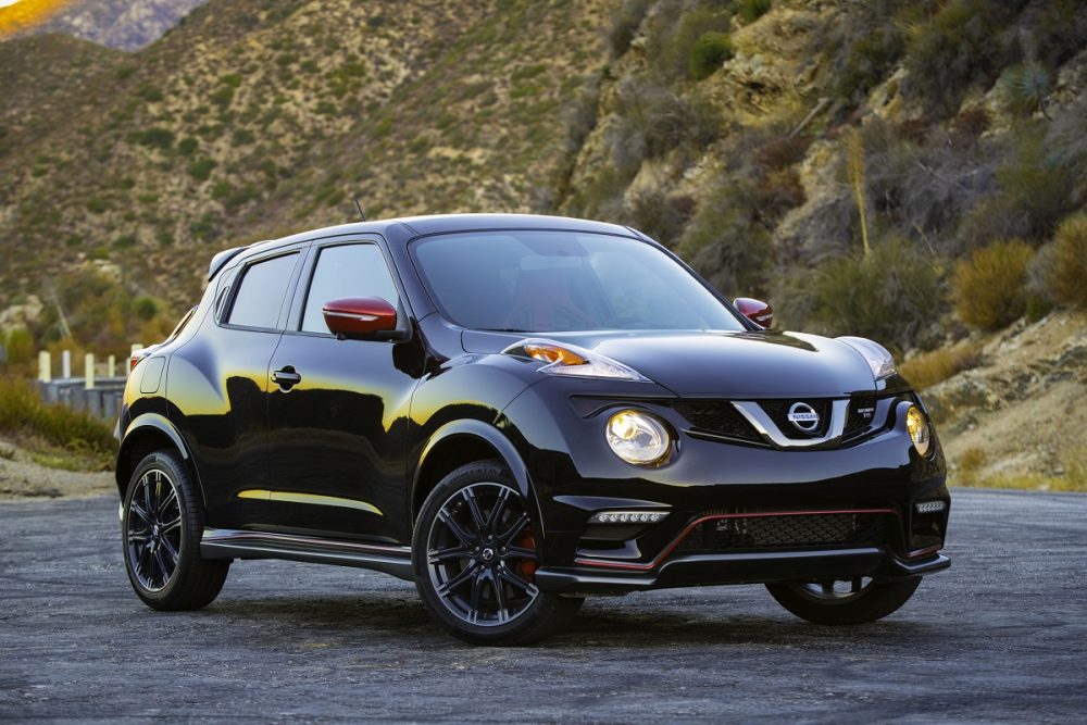 A black 2017 Nissan JUKE NISMO RS parked in front of a hilly area