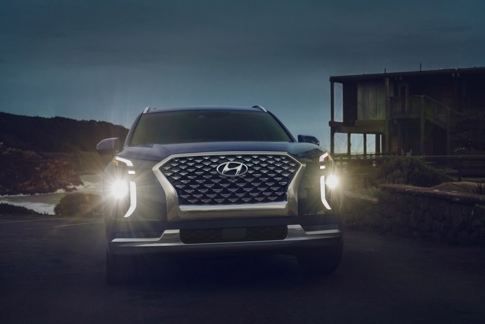 Front view of 2021 Hyundai Palisade at night with LED headlights shining