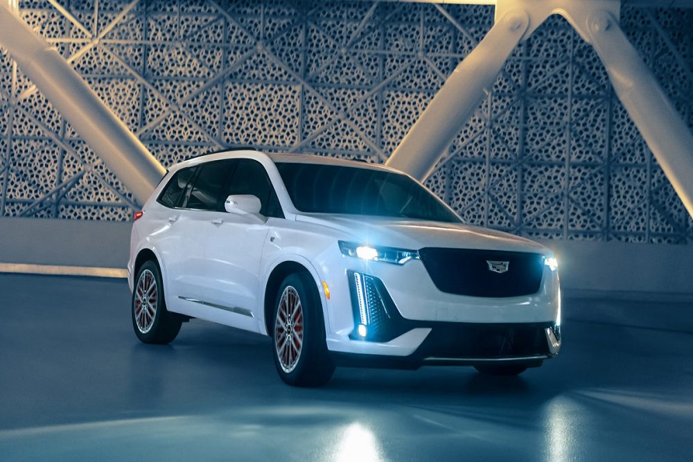 Front exterior view of a white 2022 Cadillac XT6 with its headlights on