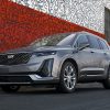 Front exterior view of a gray 2022 Cadillac XT6 parked in front of a red and white art wall