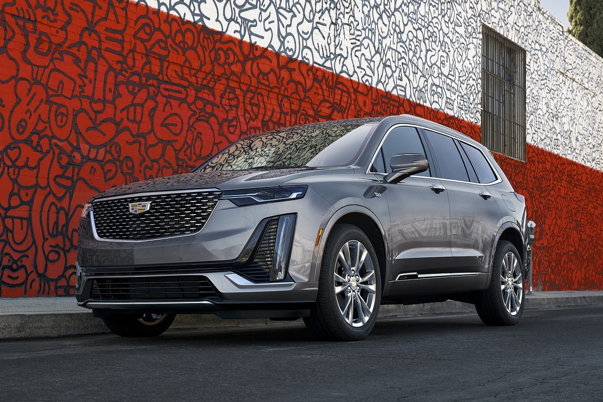 Front exterior view of a gray 2022 Cadillac XT6 parked in front of a red and white art wall