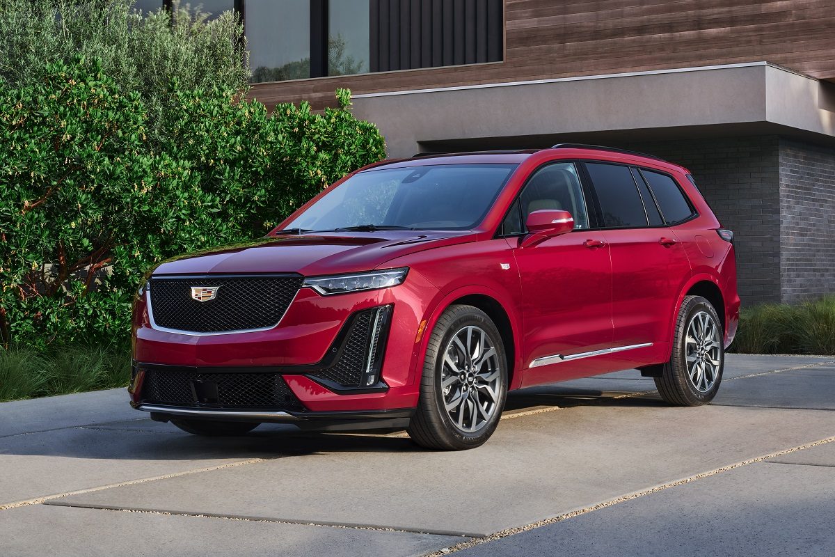 Front view of a red 2022 Cadillac XT6 parked on a driveway in front of a home