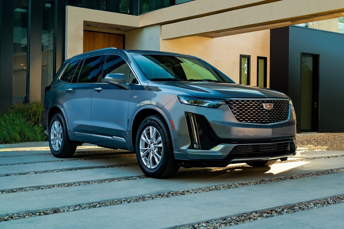 Front view of a gray 2022 Cadillac XT6 parked in front of a modern home