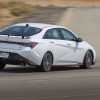 Rear side view of white 2022 Hyundai Elantra N cornering on a track