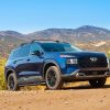 Front side view of 2022 Hyundai Santa Fe XRT on dirt path with mountain backdrop