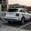 Exterior rear view of the 2022 Kia Sorento PHEV at sunset while it's getting charged