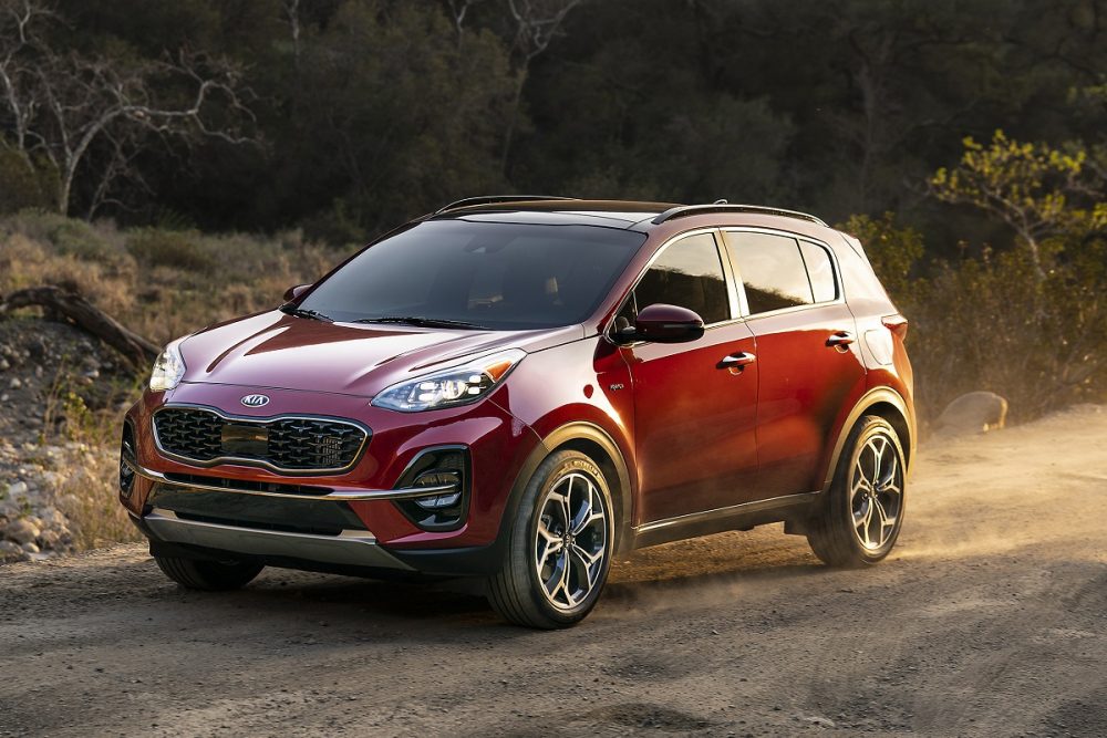 Front view of a red 2022 Kia Sportage parked on a dirt road at sunset