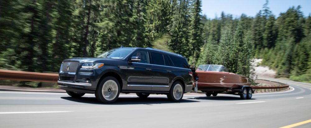 2022 Lincoln Navigator towing a boat against trees