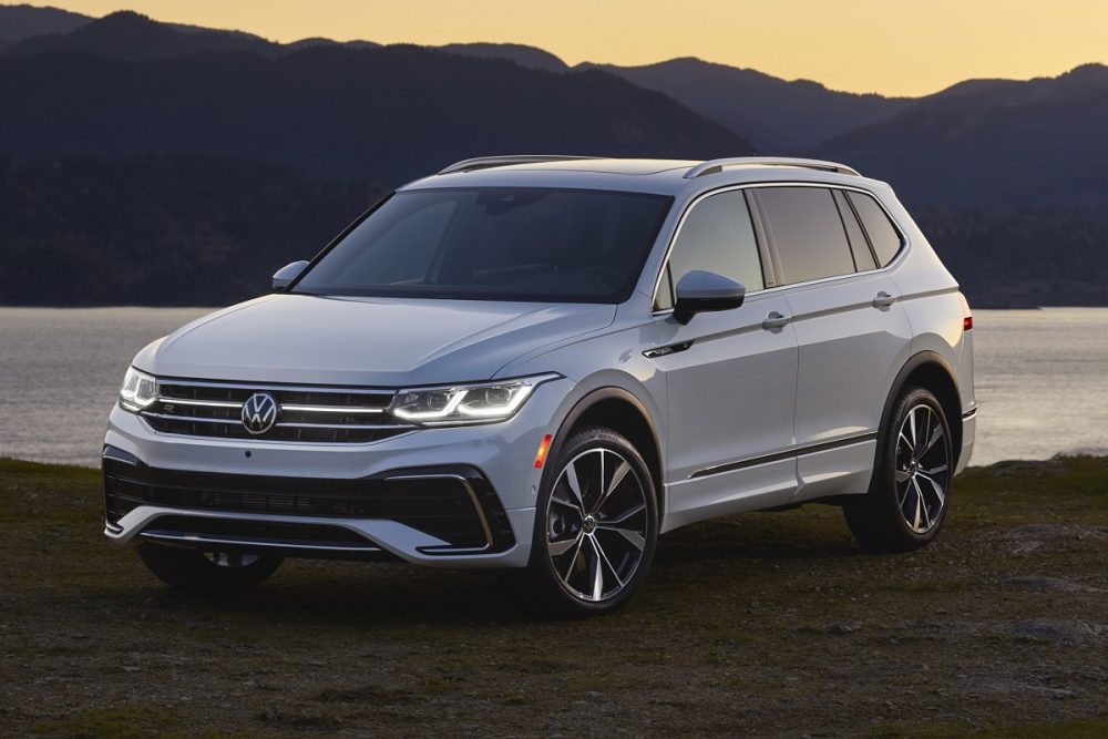 Front view of a white 2022 Volkswagen Tiguan parked at sunset in front of mountains