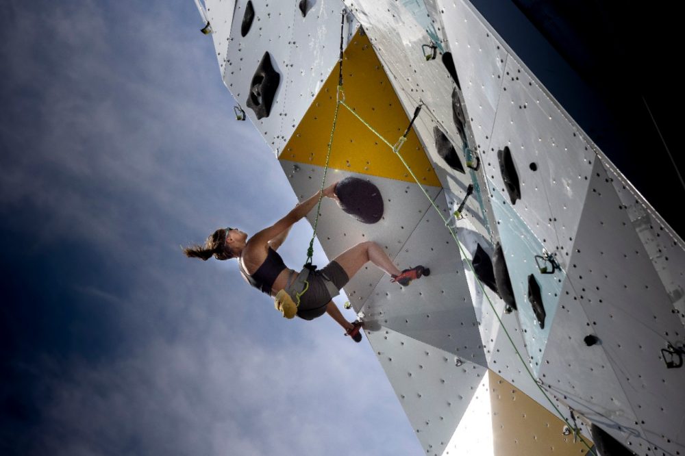 A climber hangs off the side of the OVER climbing tower in Norway