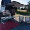 roof-mounted tent of GMC Canyon AT OVRLANDX Concept Truck with table and chairs set out