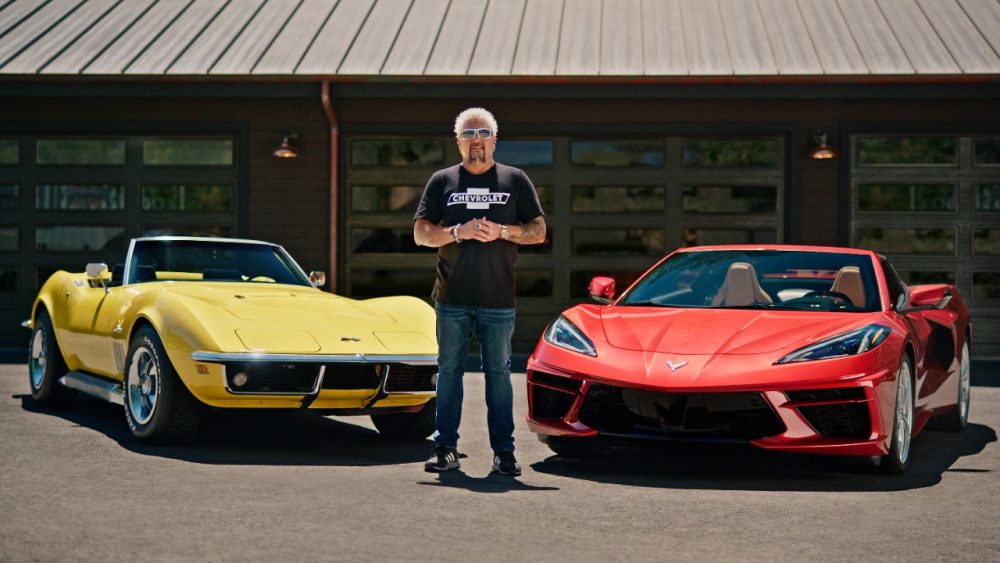 Guy Fieri wearing a Chevrolet shirt and standing between a classic yellow Chevrolet Corvette and a red 2021 Chevrolet Corvette Stingray