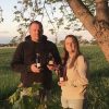 Jarrod Fortin standing with maple syrup by a maple tree at his property in South Woodslee