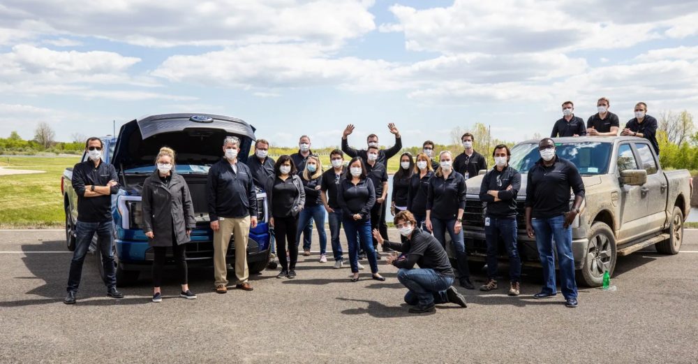 Linda Zhang with the F-150 Lightning team and a couple of F-150 Lightning trucks