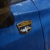 Close up of the Subaru Wilderness badge on an unknown blue Subaru model