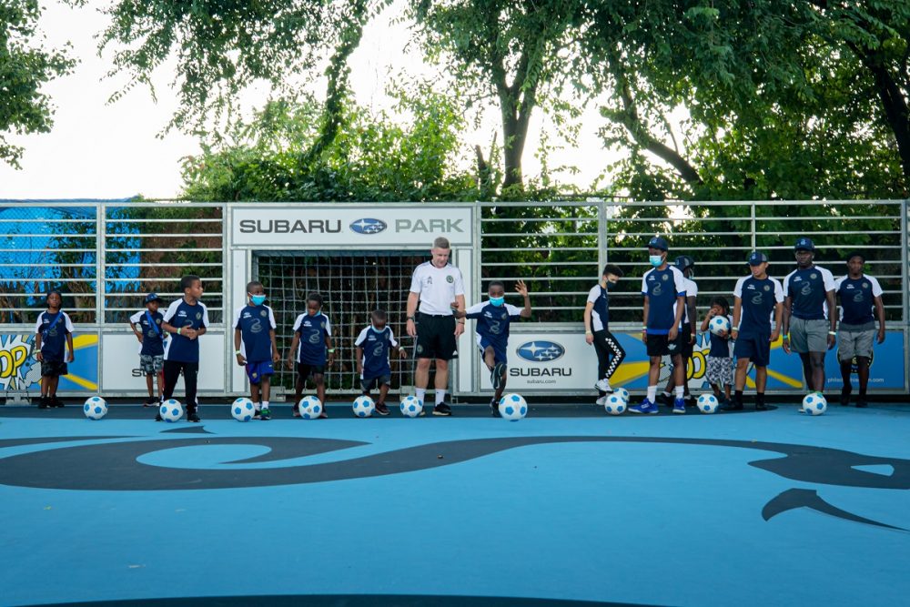 Kids from the Philadelphia YMCA play with soccer balls on the Subaru Park Camden Mini-Pitch