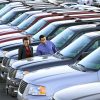 new cars parked on a dealership lot with a man and woman browsing