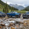 From left, the 2022 Chevrolet Silverado 1500 High Country, ZR2, and LT trims are shown in a rocky stream with mountains in the background