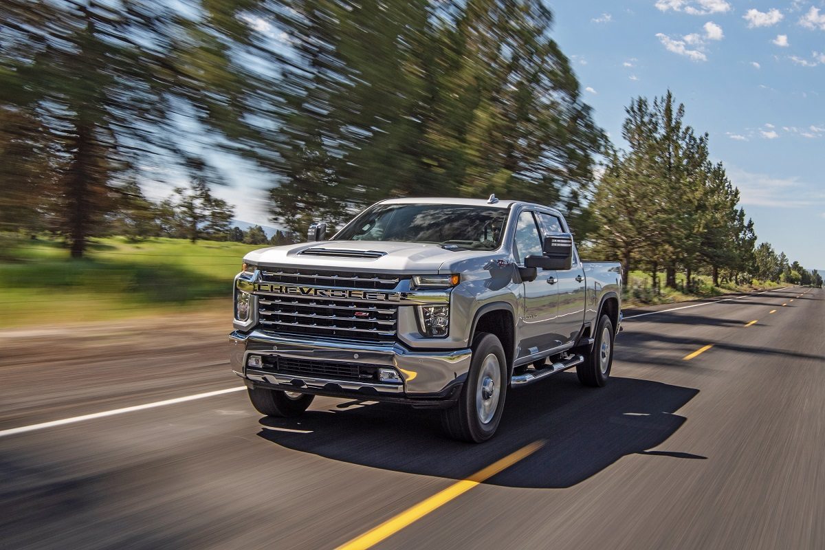 A white 2022 Chevrolet Silverado 2500HD drives along a highway