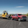 A red 2022 Chevrolet Silverado 3500HD tows work equipment