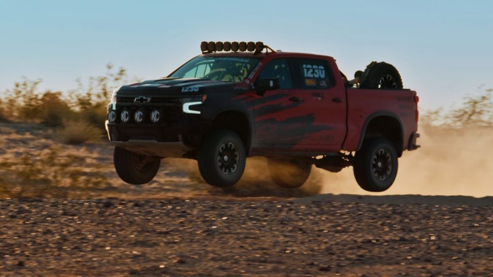 side view of a red 2022 Chevrolet Silverado on dusty desert roadZR2