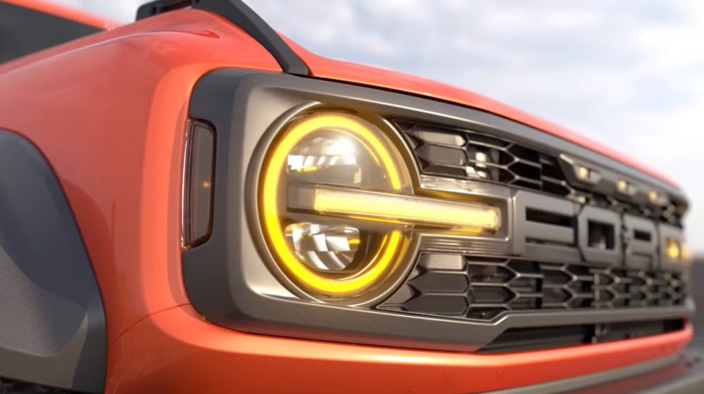 A close-up of the 2023 Ford Bronco Raptor grille, which features round headlights and a singlepiece grille with FORD lettering