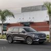 Front side view of 2022 Hyundai Santa Fe parked between palm trees in front of building